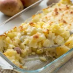 Baked potato onion casserole in white dish with golden melted cheese on top and visible layers of tender potatoes and onions