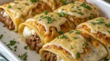 Stack of golden brown Mexican pancakes with butter melting on top and fresh strawberries on a white plate