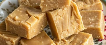 Golden brown Scottish tablet candy cut into small squares on parchment paper showing crumbly texture