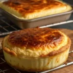 Baked egg casserole with melted cheese and cream cheese in a white baking dish with golden brown top