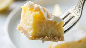 Slice of blender lemon pie on white plate with whipped cream / Lemon pie filling being poured from blender into graham cracker crust / Whole lemon pie with golden top cooling on wire rack