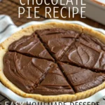 Slice of rich chocolate pie with whipped cream topping and chocolate shavings on a white plate with a fork