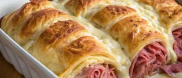 Baked crescent Reuben casserole in dish with golden brown top and layers of corned beef, sauerkraut, and melted cheese visible