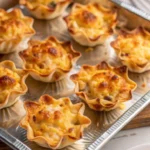 Plate of golden brown Iowa party bites showing sausage and pickle filling wrapped in crescent dough