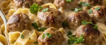 Swedish meatball noodle bake casserole in white dish with golden cheese topping and egg noodles
