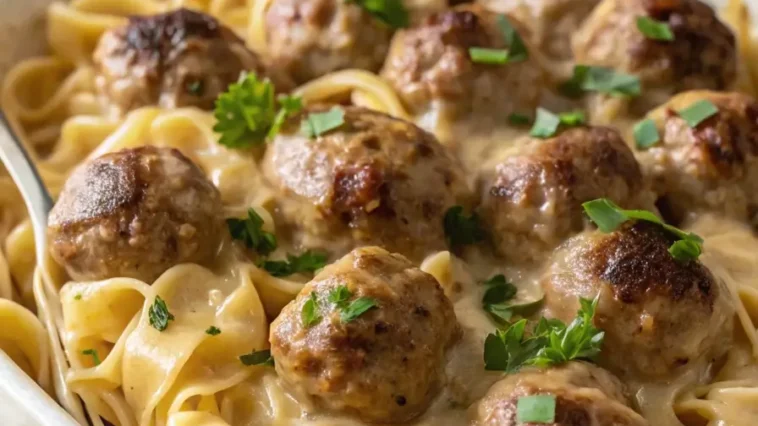 Swedish meatball noodle bake casserole in white dish with golden cheese topping and egg noodles