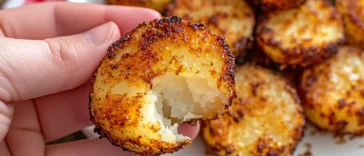 Golden roasted potato rounds topped with melted sharp cheddar and chives on a baking sheet